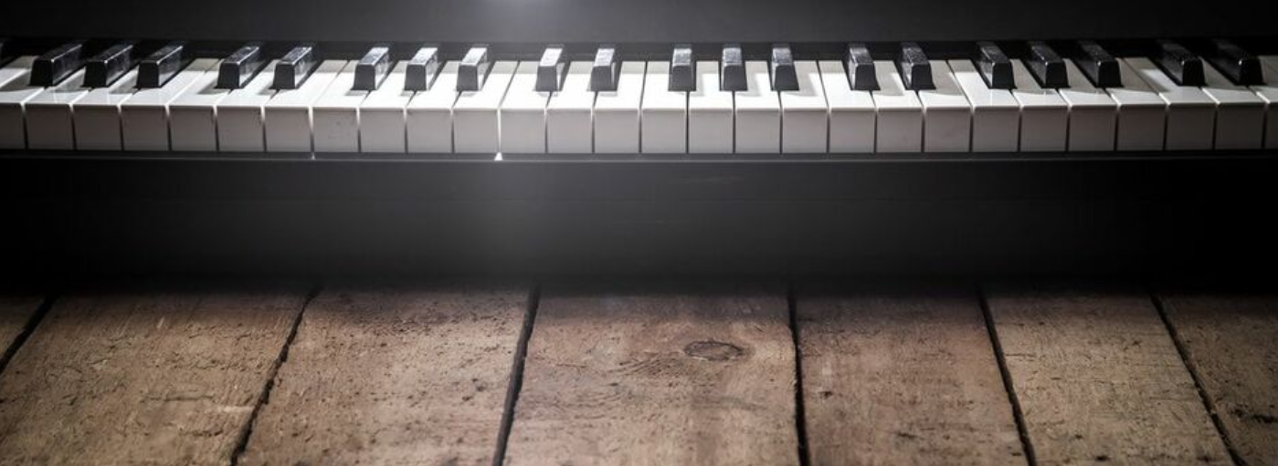 Picture of the keyboard of a piano resting on old wooden boards